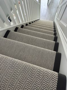 the carpeted stairs are lined with black and white herringbones on each side