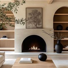 a living room filled with furniture and a fire place next to a book shelf on top of a hard wood floor