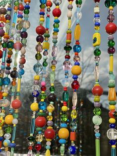 many colorful beads hanging from the side of a window