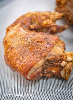 some meat is sitting on a table with other food items in the backgroud