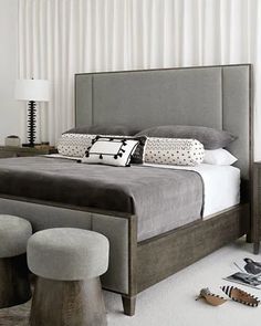 a bedroom with a bed, stools and two lamps on either side of the bed