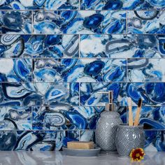 blue and white marble tile with vases on the counter top in front of it