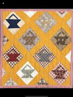 a yellow quilt with many different designs on it