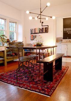 a dining room table with chairs and a rug on the floor in front of it