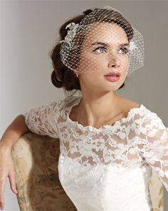 a woman wearing a veil and sitting on a chair with her hair in a bun