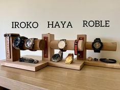 there are many different watches on the wooden display stand with words above them that read, iroko haya roble