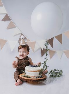 a baby is sitting in front of a cake