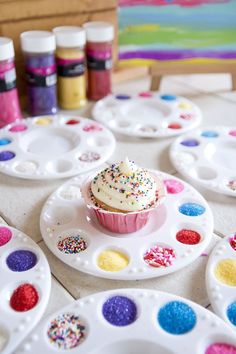 a cupcake on a plate with sprinkles and hearts in the background