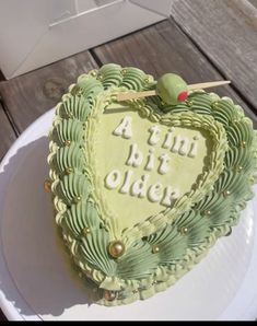 a green heart shaped cake sitting on top of a white plate