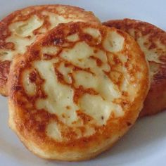 two small pizzas sitting on top of a white plate