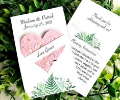 two pink hearts are on top of some green leaves, and one is for the couple