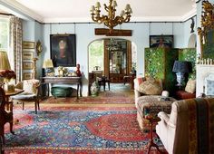 a living room filled with lots of furniture and decor on top of carpeted flooring