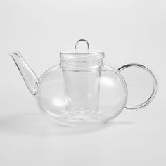 a glass teapot with a clear lid and handle on the top, sitting in front of a white background