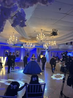 a group of people standing in a room with chandeliers