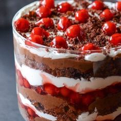 a chocolate cake with cherries on top and white frosting in the bottom layer