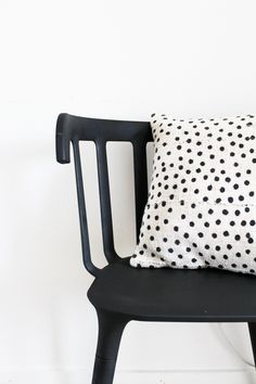 a black chair with a polka dot pillow on it