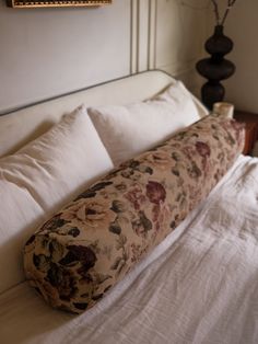 a large pillow sitting on top of a white bed