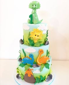 a three tiered cake with dinosaurs on it