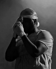 a man in white shirt and head band holding a cell phone up to his ear