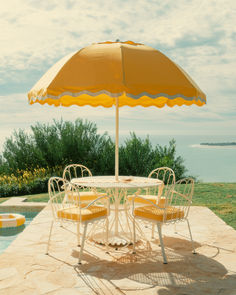 A luxurious outdoor setup featuring the Patio Umbrella, showcasing a nostalgic coastal European design. The umbrella’s high-quality materials, including stainless steel, aluminum, and teakwood, ensure durability and elegance, making it perfect for withstanding daily use in both commercial and residential settings. Coastal Charm, Timeless Style, Patio Umbrella, Outdoor Spaces, Outdoor Space, Beach House, Timeless Fashion, Umbrella, Patio