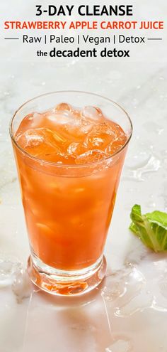 an orange drink in a glass with ice and garnish