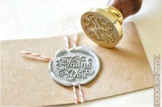 a wax stamp with the words thank you on it next to some candy canes