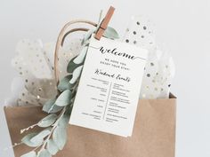 a brown paper bag with a welcome sign on it and some greenery around it