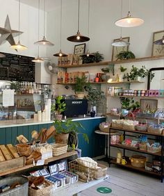 the inside of a store filled with lots of food and drinks on shelves next to hanging lights