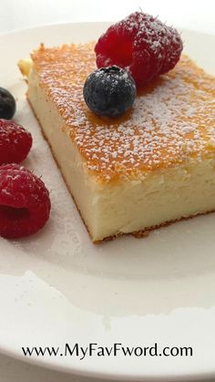 a piece of cheesecake with berries on top and powdered sugar on the side