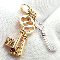 About This Piece: This rare Louis Vuitton charm pendant features three keys, each crafted from 18k gold in three distinct colors: yellow, white, and rose. The rose gold key is elegantly adorned with red enamel to form a heart shape, showcasing LV's exqmbolic pieuisite attention to detail. A luxurious and syce, it embodies love and sophistication. Metal: 18k Yellow, Rose, and White Gold  Size: 38mm Total Each key is 8mm wide  Weight: 5.4 grams  Hallmarks: LV 750   Please refer to the dimensions in the description above for accurate measurements. Please reach out to the seller with any questions on dimensions or fit prior to purchase. Luxury White Gold Charms For Gift, Elegant Pendant Charms With Logo, Elegant Logo Charm Pendant, Elegant Pendant Logo Charm, Luxury Engraved Yellow Gold Charms, Luxury Yellow Gold Pendant Charms, Luxury Gold Jewelry With Keys, Elegant Yellow Gold Logo Charm, Yellow Gold Key Pendant Jewelry