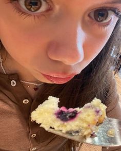 a close up of a person holding a spoon with food in it's mouth