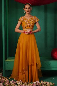 Yellow lehenga in solid base with overlap asymmetric panel. Comes with floral embroidered cross panel blouse and pearl tassels. - Aza Fashions Fitted V-neck Wedding Sets, V-neck Lehenga For Navratri, Fitted V-neck Anarkali Sets, Fitted Anarkali Set With Cape Sleeves For Diwali, Fitted Anarkali Set With Cape Sleeves For Reception, Fitted V-neck Pre-draped Saree, Designer Georgette V-neck Sets, Party Wear V-neck Sets With Sheer Dupatta, Bollywood Style V-neck Choli In Georgette