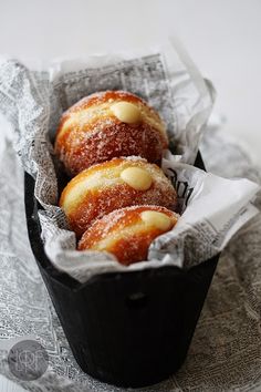 three pastries in a black container on a table