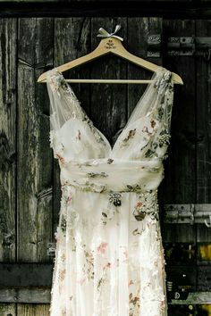 a white dress hanging on a wooden wall