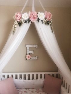 a white crib with pink and white flowers on it