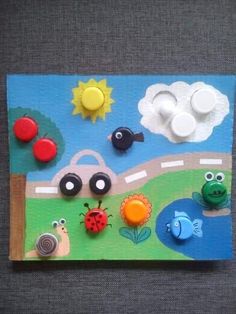 a child's artwork made out of paper with buttons and magnets on it