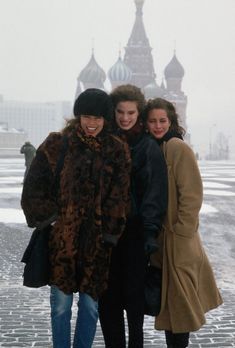 three women standing next to each other in the snow