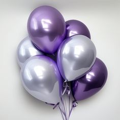 a bunch of balloons that are purple and white