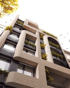 an apartment building with plants growing on the balconies