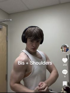 a young man wearing headphones standing in front of a mirror with the words bis + shoulderrs on it