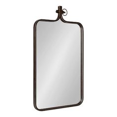 a large rectangular mirror with an iron frame and metal accents on the top, against a white background