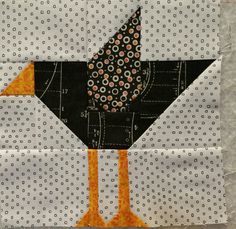 the bird is made up of black and white fabric, with orange dots on it