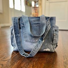 an old pair of jeans is sitting on the floor in front of a purse that has been ripped