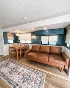 a living area with couch, table and rug in front of the kitchenette door