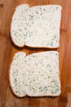 two pieces of bread with cheese and herbs on them