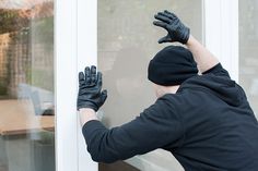 a man wearing black gloves is opening the glass door