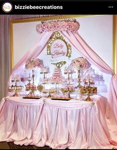 a table with pink and gold desserts on it's sides under a canopy