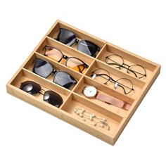 an open wooden drawer containing several pairs of glasses