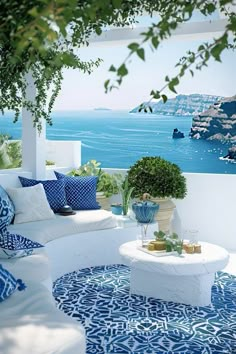 an outdoor living area with blue and white decor on the walls, couches and tables