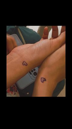 two people with matching tattoos on their legs holding remotes and looking at each other